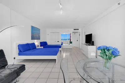 a living room with a blue couch and a glass table at 530 - Miami Beach Large studio Ocean View in Miami Beach