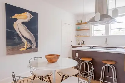 a kitchen with a glass table and stools at Designer 2BR Condo, 5 Mins to Sand, Free Parking in Hollywood