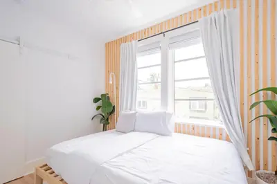 a bedroom with a white bed and a window at Designer 2BR Condo, 5 Mins to Sand, Free Parking in Hollywood
