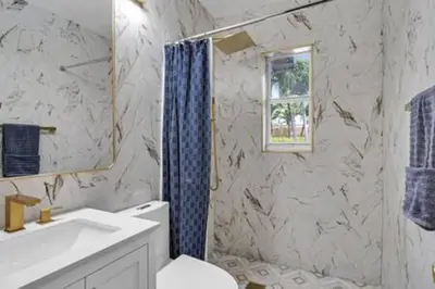 a bathroom with a sink and a toilet and a window at 437 NE 107th · Pool Hot Tub Patio 5 Bedrooms 3 BathsParking in Miami Shores