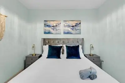 a bedroom with a large white bed with blue pillows at 437 NE 107th · Pool Hot Tub Patio 5 Bedrooms 3 BathsParking in Miami Shores