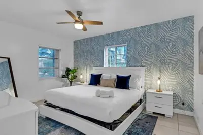 a bedroom with a white bed and a ceiling fan at 437 NE 107th · Pool Hot Tub Patio 5 Bedrooms 3 BathsParking in Miami Shores
