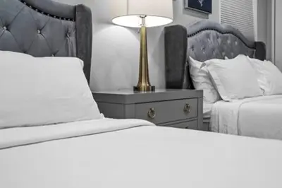 a bedroom with two beds and a lamp on a night stand at 427 NE 107th Studio · 6BR 3BA 7 Beds Pool Parking 2 Kitchen in Miami Shores