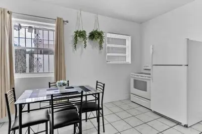 a kitchen with a table with chairs and a refrigerator at 1834 SW 27th Ave 2 · Vibrant Miami Getaway 2 Beds Near Beach Port in Miami