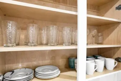 a shelf filled with glasses and plates and cups at 1720 Wa Kee 2A · Luxurious 4BR 3BA Retreat in Coconut Grove w Pool in Miami