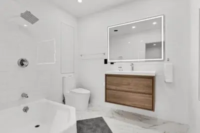 a bathroom with a sink and a toilet and a mirror at 1720 Wa Kee 2A · Luxurious 4BR 3BA Retreat in Coconut Grove w Pool in Miami