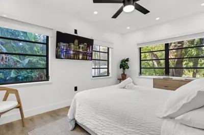 a white bedroom with a bed and two windows at 1720 Wa Kee 2A · Luxurious 4BR 3BA Retreat in Coconut Grove w Pool in Miami