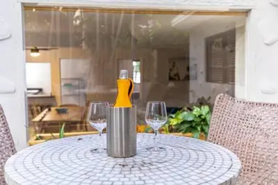 a table with two wine glasses and a bottle on it at 1720 Wa Kee 1B · 4 Queen Beds Sleep 8 Pool Parking Wi-Fi Patio in Miami