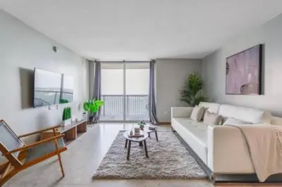 a living room with a white couch and a table at Brickell 3802 · Picturesque Bay Views Pool Sleeps 8 Gym in Miami