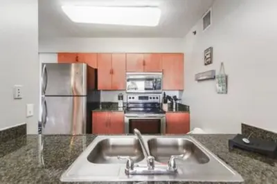 a kitchen with a sink and a stainless steel refrigerator at Brickell 3802 · Picturesque Bay Views Pool Sleeps 8 Gym in Miami