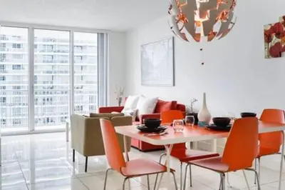 a dining room with a table and orange chairs at Waterfront 1BR w Bay ViewsBalcony Full Kitchen in Miami