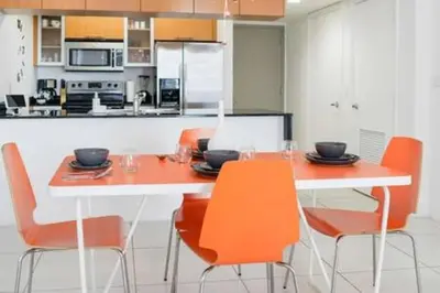 a kitchen with orange chairs and a white table at Waterfront 1BR w Bay ViewsBalcony Full Kitchen in Miami