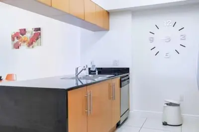 a kitchen with a sink and a clock on the wall at Waterfront 1BR w Bay ViewsBalcony Full Kitchen in Miami