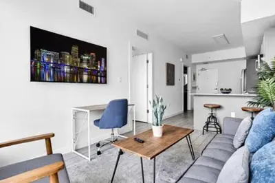 a living room with a couch and a table and a kitchen at Modern 1BR Apt In Edgewater Free Parking in Miami