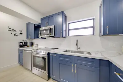 a kitchen with blue cabinets and stainless steel appliances at 3 Mi to Hard Rock Stadium Retreat with Private Yard in Miramar