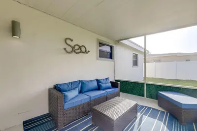 a patio with a couch and a table and a window at 3 Mi to Hard Rock Stadium Retreat with Private Yard in Miramar