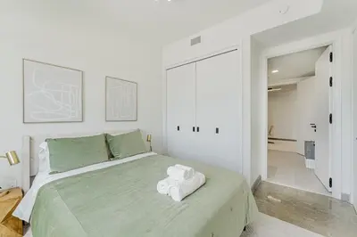 a bedroom with a large bed with towels on it at KOOSH - Boutique Aparthotel in Fort Lauderdale