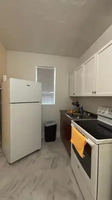a kitchen with white cabinets and a white refrigerator at The Studio 6 Little Havana Walk to Marlins Stadium in Miami