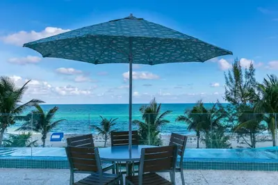a table and chairs under an umbrella on the beach at Marenas Beach Resort Private Luxury Suites in Miami Beach