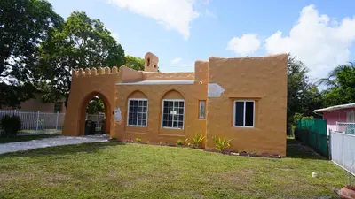 a home in the middle of a yard at Charming Historic Home with Modern Comforts in Opa-locka