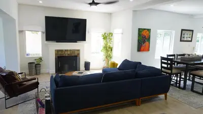 a living room with a blue couch and a fireplace at Charming Historic Home with Modern Comforts in Opa-locka