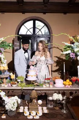 a bride and groom standing in front of a table with a cake at Young Mansion Steps To The Beach in Hollywood
