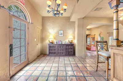 a living room with a chandelier and a room with a table at Young Mansion Steps To The Beach in Hollywood