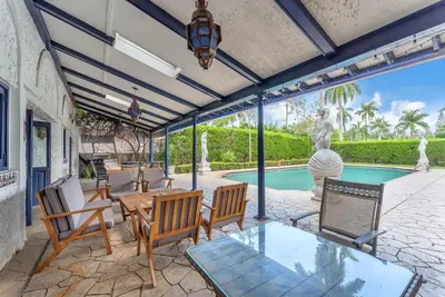 a patio with chairs and a table and a pool at Young Mansion Steps To The Beach in Hollywood