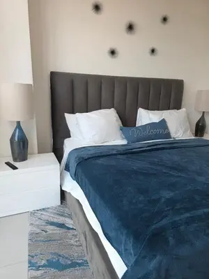 a bedroom with a large bed with a blue blanket at Sweetie Doral studio in Miami