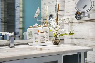 a bathroom counter with three bottles of soap and flowers at Oceanview Private Home at South Beach-814 1B in Miami Beach