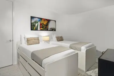 two beds in a room with white walls at Oceanview Private Home at South Beach-814 1B in Miami Beach