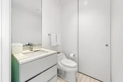 a white bathroom with a toilet and a sink at Oceanview Private Home at South Beach-814 1B in Miami Beach