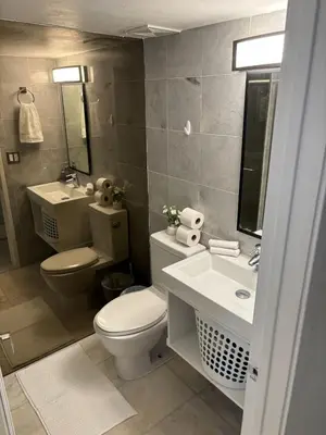 a bathroom with a toilet and a sink and mirror at Knickerbocker 102 in Miami Beach