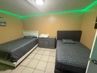 two beds in a room with green lights at The Luxe Loft in Fort Lauderdale