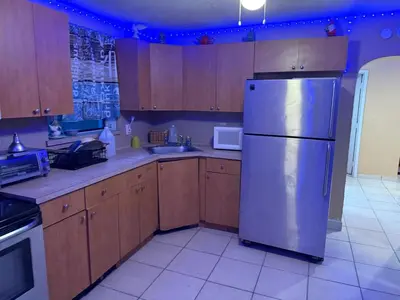 a kitchen with wooden cabinets and a stainless steel refrigerator at The Luxe Loft in Fort Lauderdale
