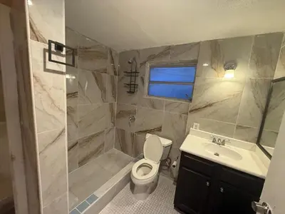 a bathroom with a toilet and a sink and a shower at The Luxe Loft in Fort Lauderdale