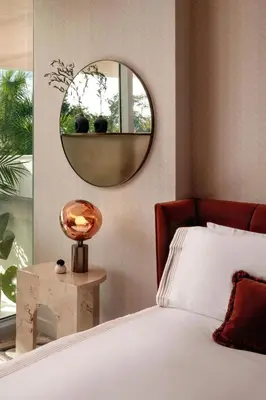 a bedroom with a bed and a round mirror at UNFRAMED Miami Beach, Autograph Collection in Miami Beach