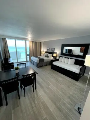 a hotel room with two beds and a table at Shine Suites Balcony Studio 7 in Miami Beach