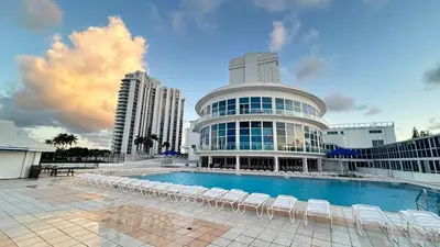 a large building with chairs and a swimming pool at Shine Suites Balcony Studio 7 in Miami Beach