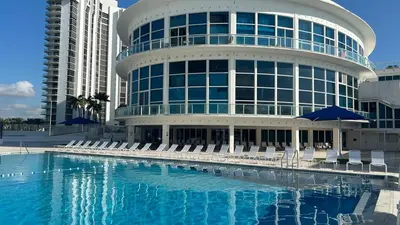 a large building with chairs and a swimming pool at Shine Suites Balcony Studio 7 in Miami Beach