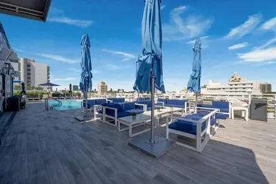 a patio with blue and white chairs and umbrellas at Modern Studio in the Heart of South Beach in Miami Beach