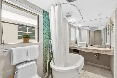 a bathroom with a tub and a toilet and a sink at Modern Studio in the Heart of South Beach in Miami Beach