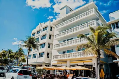 a white building with palm trees in front of it at Modern Studio in the Heart of South Beach in Miami Beach