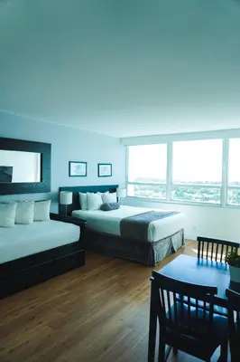 a bedroom with two beds and a table and chairs at Shine Suites Studio 11 in Miami Beach