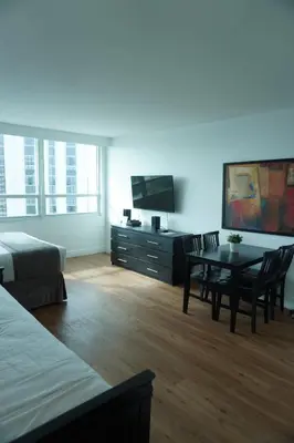 a room with a bed and a table and a tv at Shine Suites Studio 11 in Miami Beach
