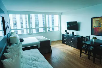 a bedroom with a bed and a desk and a television at Shine Suites Studio 11 in Miami Beach