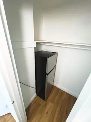 a small black refrigerator in a corner of a room at Shine Suites Studio 11 in Miami Beach
