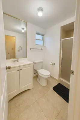 a bathroom with a toilet and a sink and a mirror at Stylish Wynwood studio in Miami