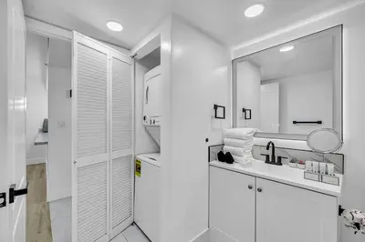 a white bathroom with a sink and a mirror at Amazing property with amenities in Miami