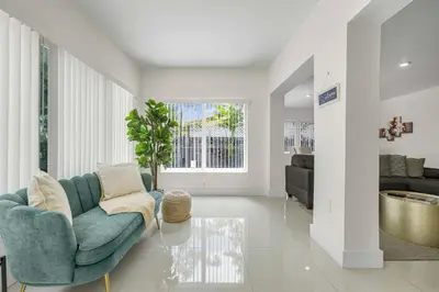 a living room with a blue chair and a couch at Modern 4BR Retreat with Private Pool - Near Brickell in Miami